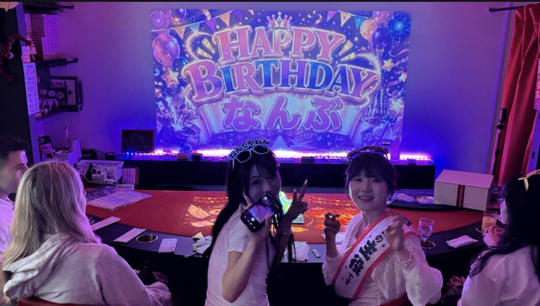 女子会でスクリーンの誕生日メッセージを楽しむお客様